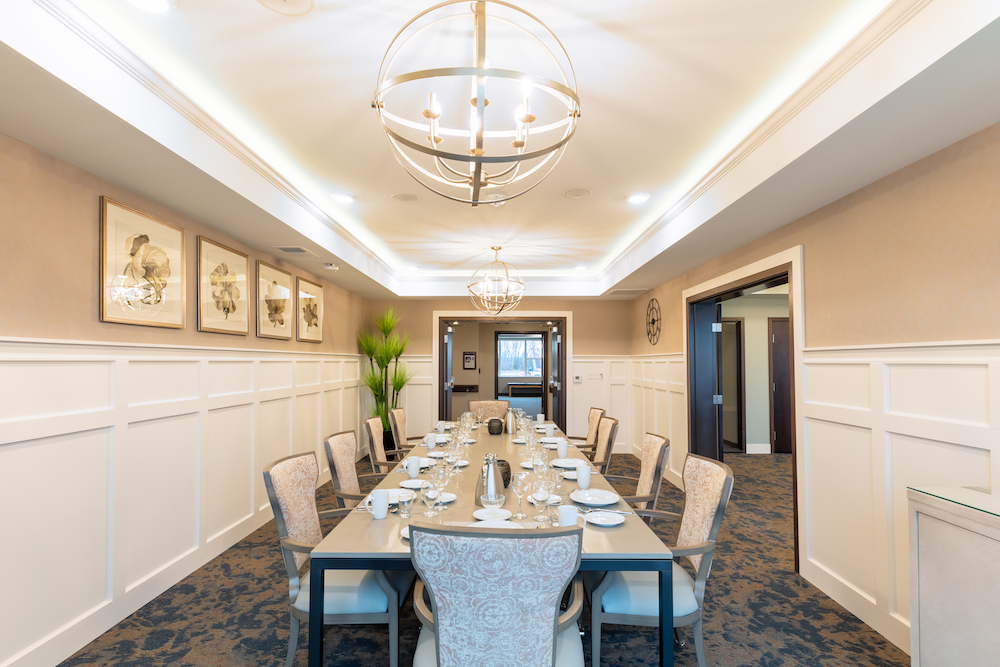 Elegant dining room with a long table set for a meal in a warmly lit, luxurious space.