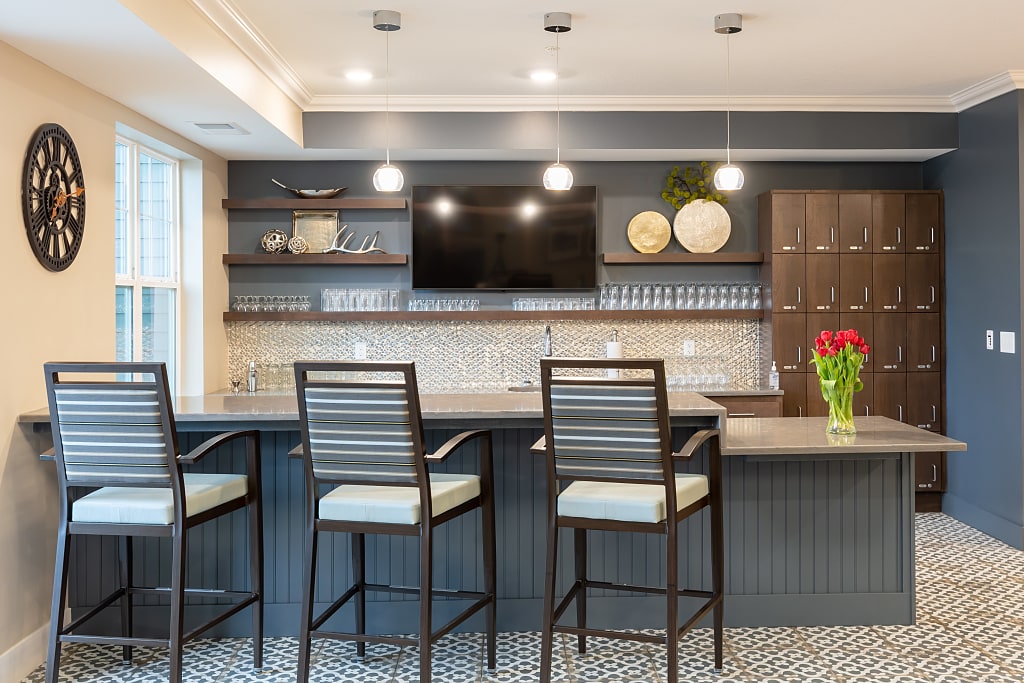 Rustic bar with three barstools and wall-mounted TV